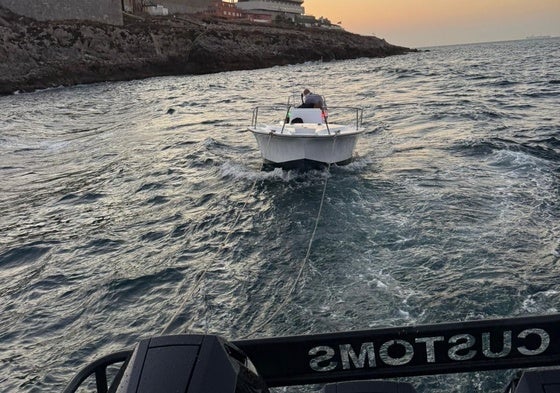 The small boat being towed back to the marina.