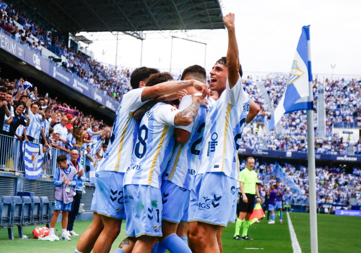 Malaga players celebrate Antoñito after scoring the penalty.