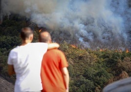 People helplessly watching a fire ravage the O Courel mountain range.